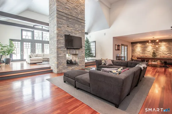 a living room with furniture a flat screen tv and a large window