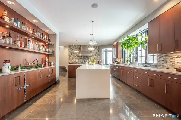 a large kitchen with kitchen island granite countertop lots of counter top space and wooden floor