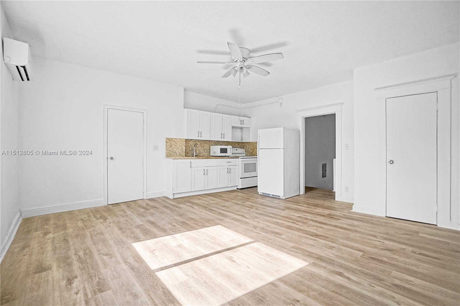 1924 Southwest 9th Street Miami, FL 33135 - Photo 13 of 23 a view of a room with wooden floor and ceiling fan