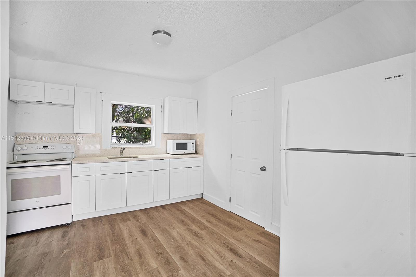 1924 Southwest 9th Street Miami, FL 33135 - Photo 15 of 23 a kitchen with white cabinets and white appliances