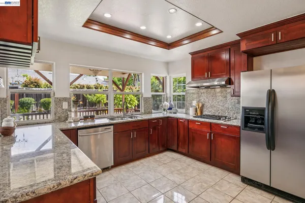 a kitchen with stainless steel appliances granite countertop a sink dishwasher stove and refrigerator