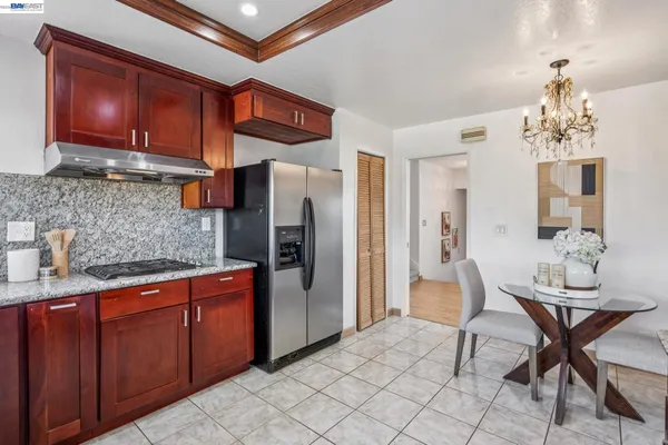 a kitchen with stainless steel appliances granite countertop a refrigerator and a stove top oven