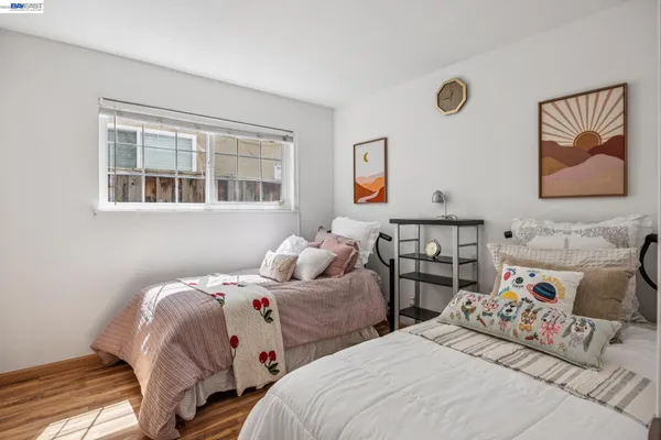 a bedroom with two beds and a painting on the wall