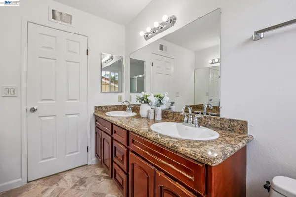a bathroom with a granite countertop sink and a mirror