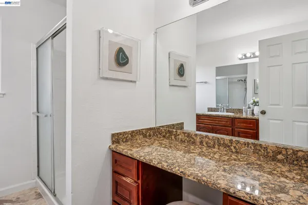 a bathroom with a granite countertop sink and a mirror
