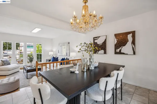 a view of a dining room with furniture a chandelier and wooden floor