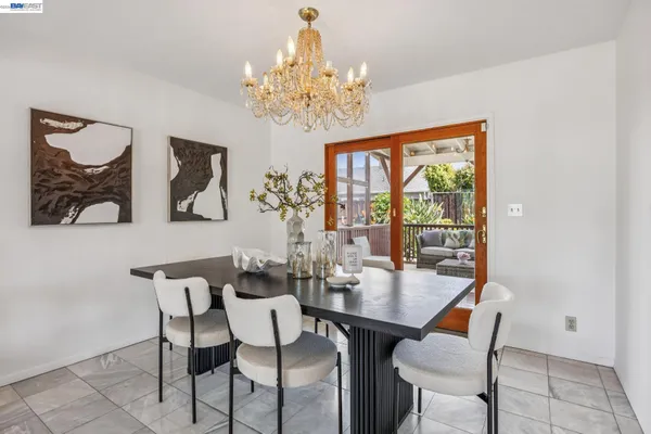 a view of a dining room with furniture a chandelier and wooden floor