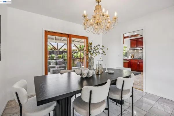 a view of a dining room with furniture a chandelier and window