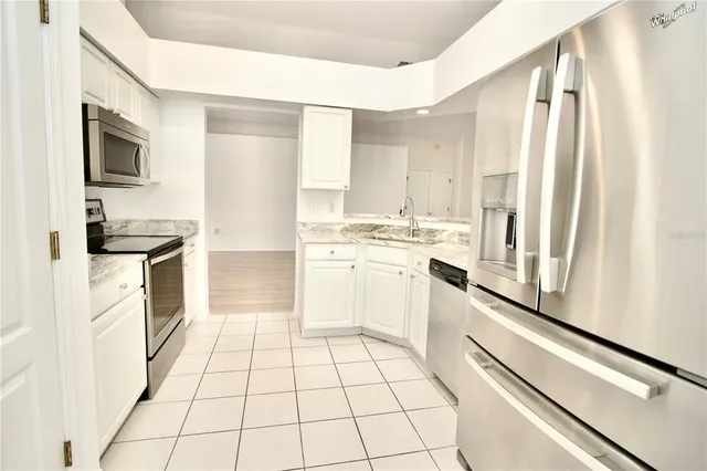 a kitchen with granite countertop white cabinets and white appliances