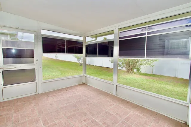 a view of a yard with plants and large trees