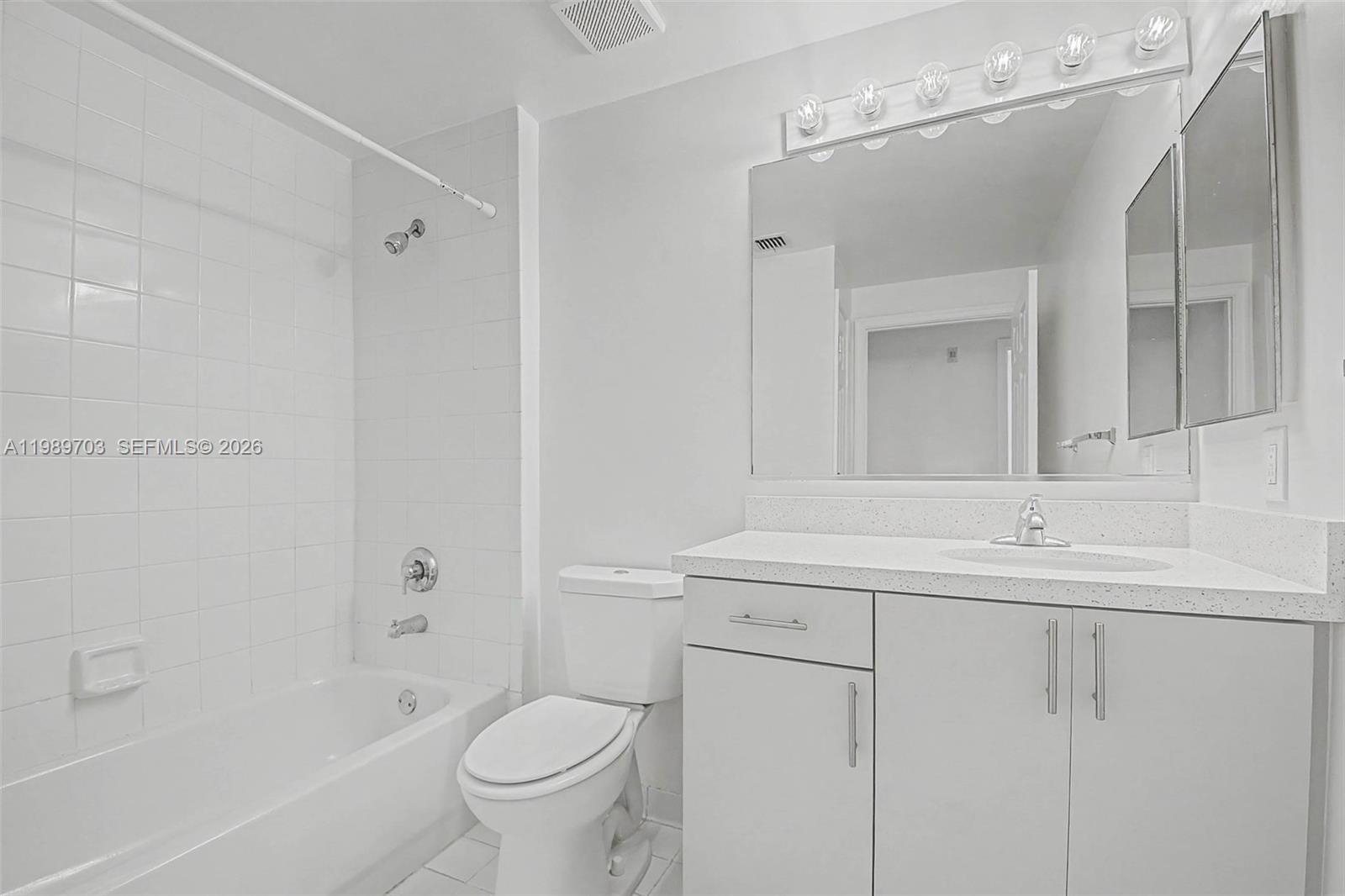 7000 Southwest 80th Street, Unit 103 Miami, FL 33143 - Photo 13 of 16 a bathroom with a sink a toilet and a mirror