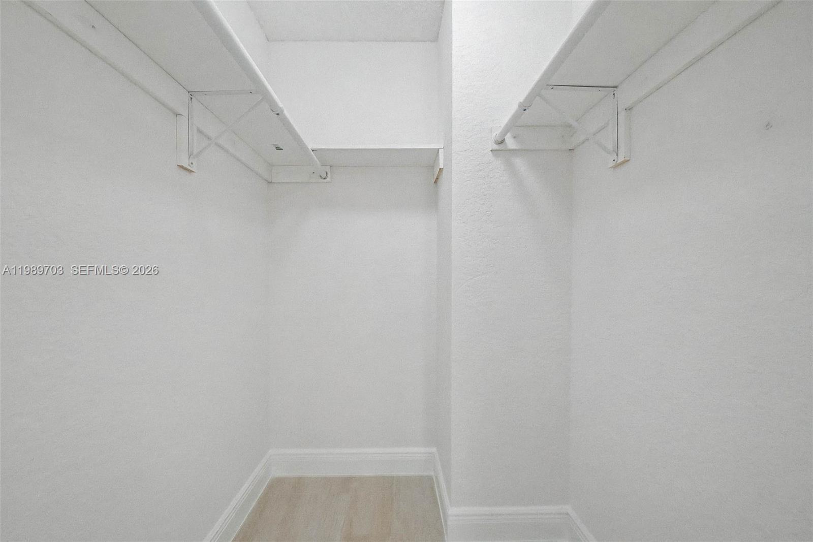 7000 Southwest 80th Street, Unit 103 Miami, FL 33143 - Photo 14 of 16 a view of walk in closet with racks on the wall
