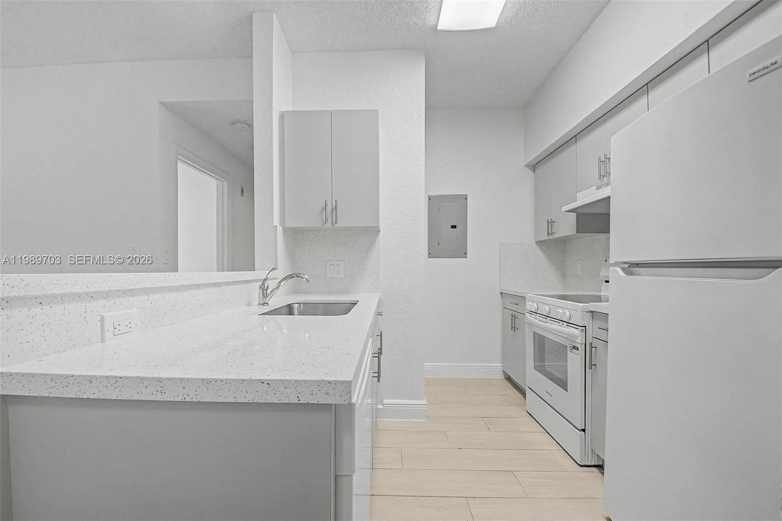 7000 Southwest 80th Street, Unit 103 Miami, FL 33143 - Photo 8 of 16 a kitchen with stainless steel appliances granite countertop a sink and a stove