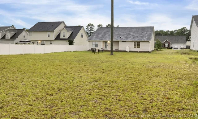 a backyard of a house with table and chairs