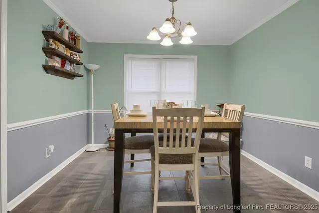 a view of a dining room with furniture and chandelier