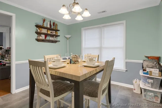 a view of a dining room with furniture and chandelier