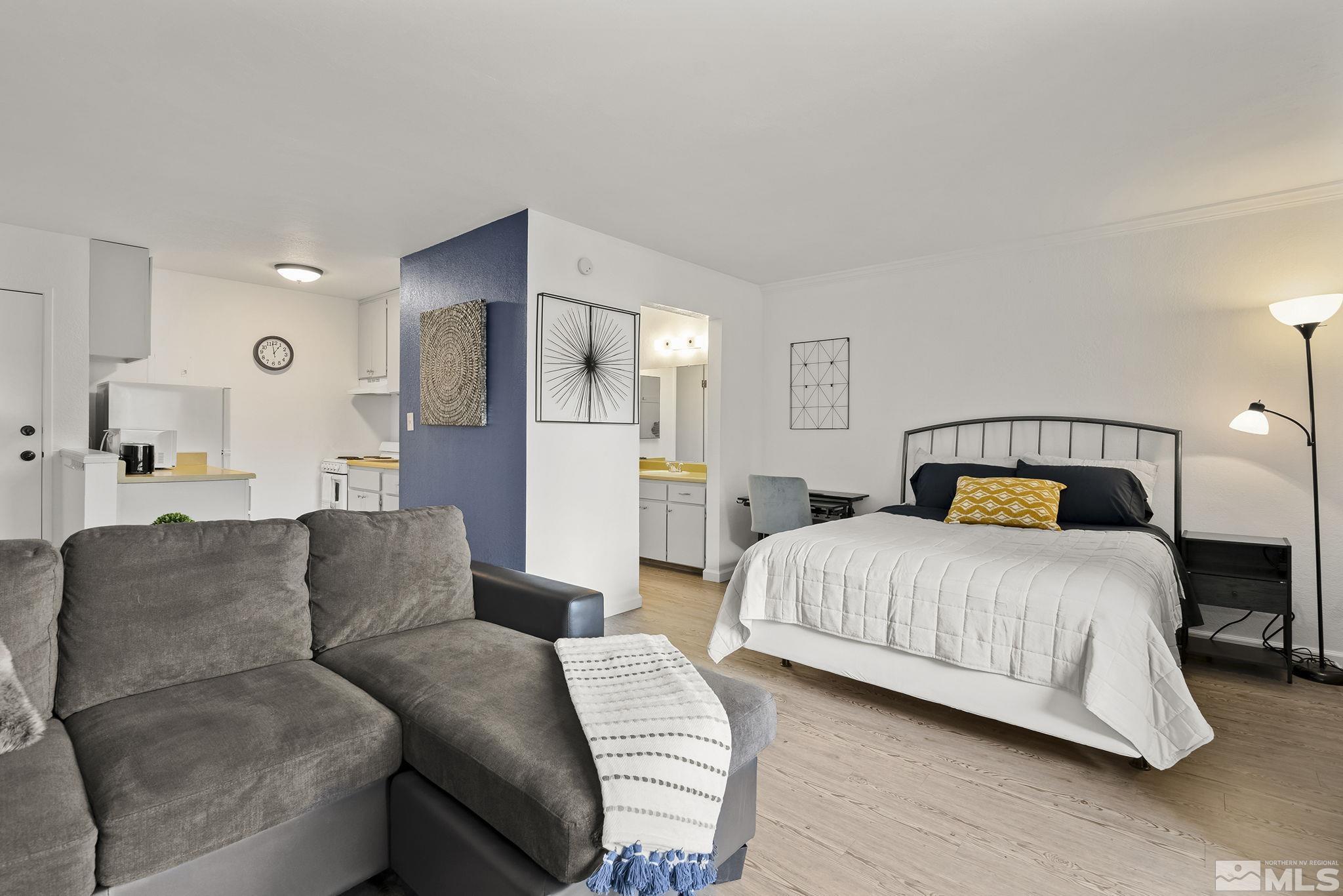 2450 Lymbery Street, Unit 214 Reno, NV 89509 - Photo 1 of 13 a spacious bedroom with a bed and a lamp