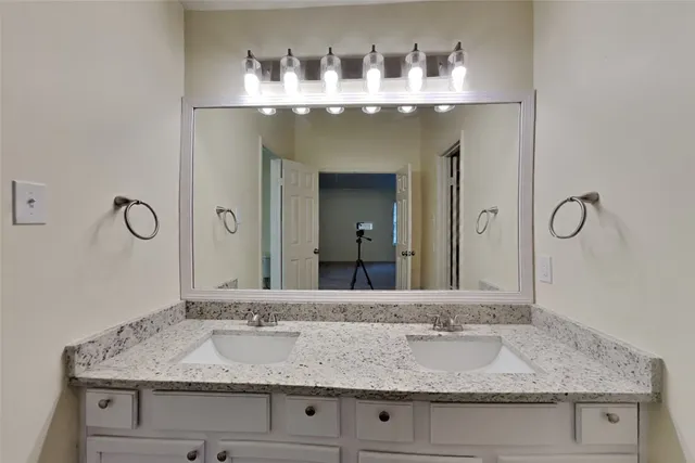 a bathroom with a granite countertop sink and a mirror