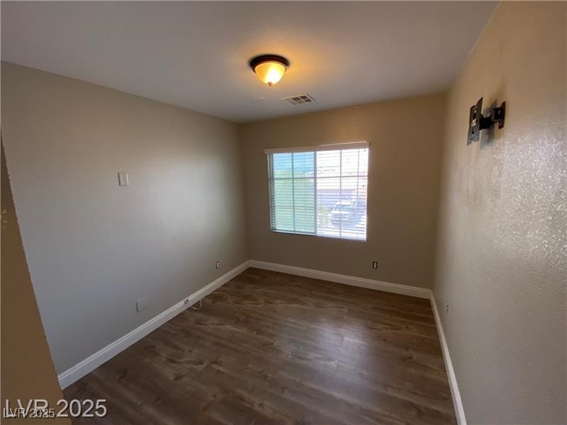 1154 Warm Sun Court Las Vegas, NV 89110 - Photo 5 of 19 Empty room with dark wood-style flooring and baseboards