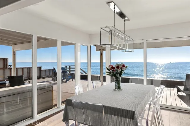a dining room with furniture and large windows