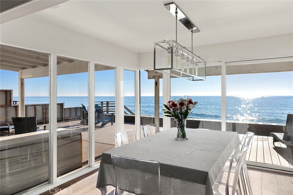 35661 Beach Road Dana Point, CA 92624 - Photo 20 of 52 a kitchen with stainless steel appliances kitchen island granite countertop a table chairs in it and wooden floors