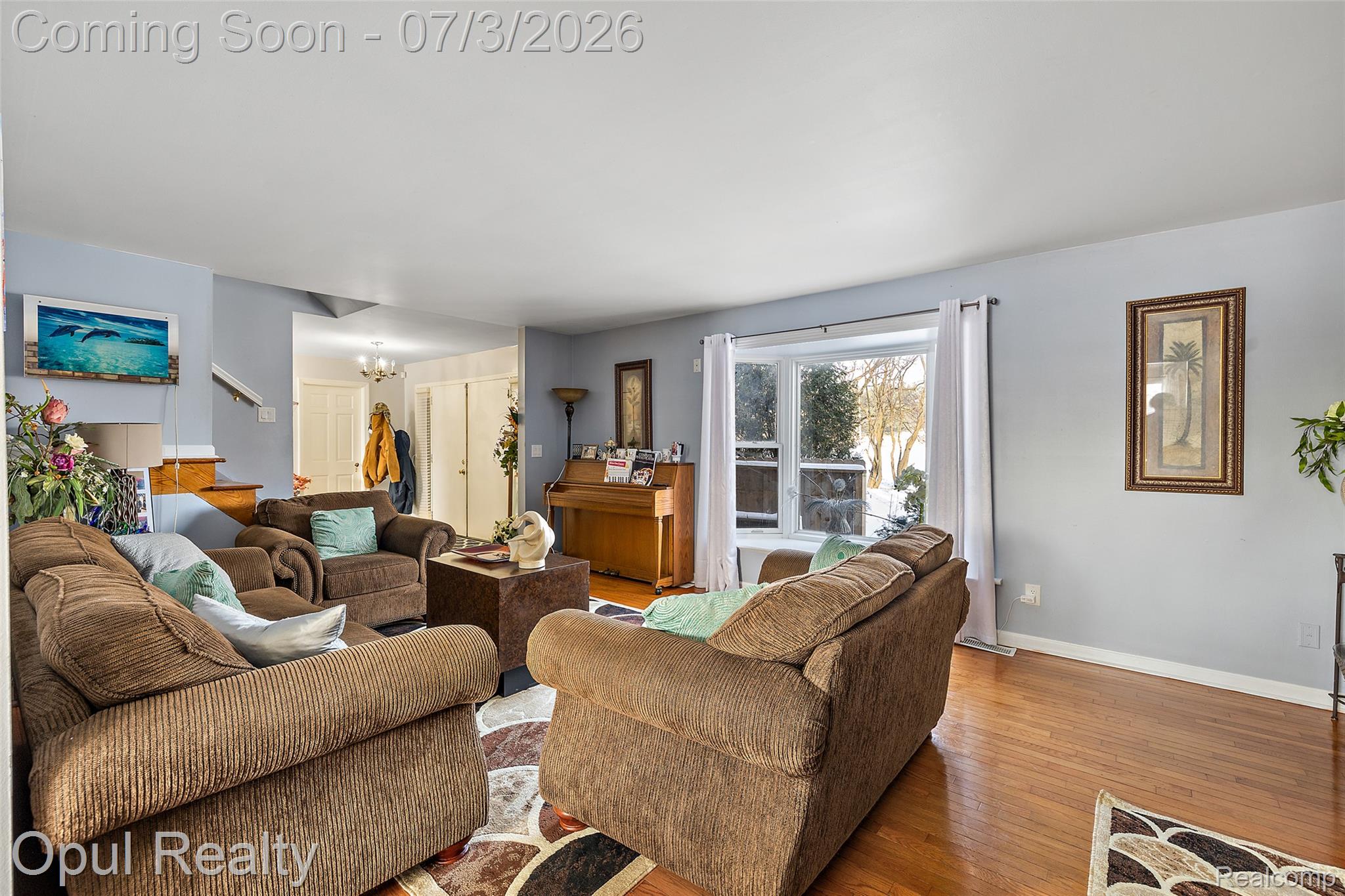 8855 Gross Road Dexter, MI 48130 - Photo 22 of 53 Spacious living area featuring hardwood flooring, light blue wall paint, and a bay window