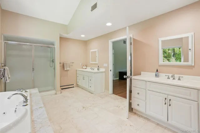 a spacious bathroom with a mirror a sink and a bathtub