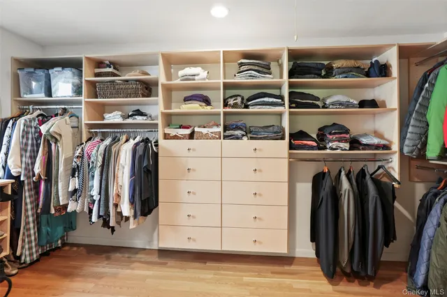 a view of walk in closet with clothes and shoes