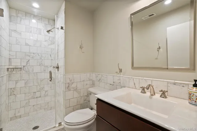 a bathroom with a sink toilet a mirror and shower