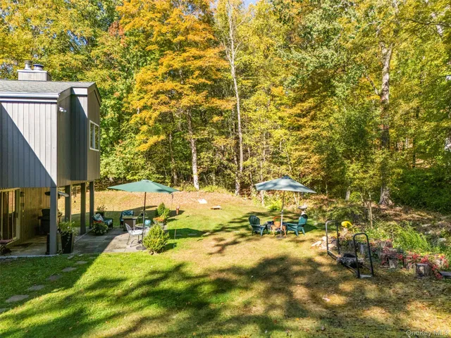 a view of swimming pool with lawn chairs and large trees