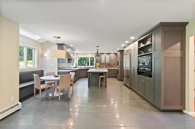 a kitchen with a table chairs refrigerator and microwave