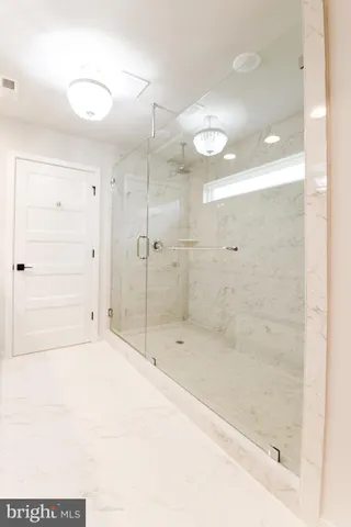 a bathroom with a shower and a glass door