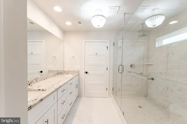 a bathroom with a granite countertop sink a shower and a mirror