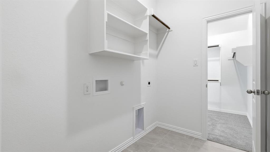 2529 Rivers W Road Anna, TX 75409 - Photo 36 of 40 Laundry area featuring built-in shelving, a clothes hanging rod, tile flooring, and white baseboards