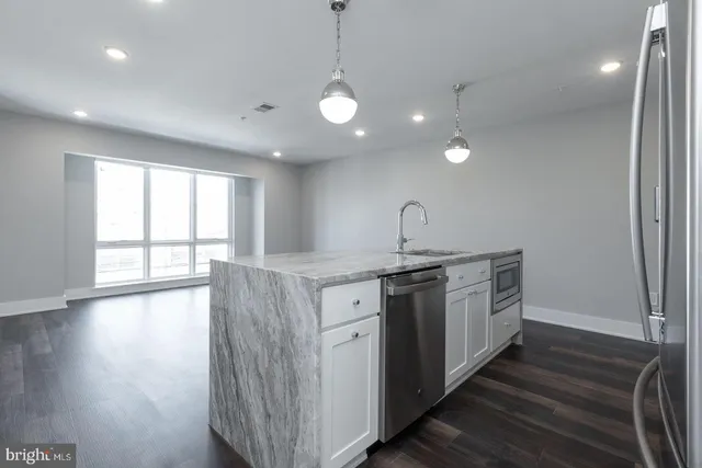 a kitchen with stainless steel appliances granite countertop a sink a stove and a large window