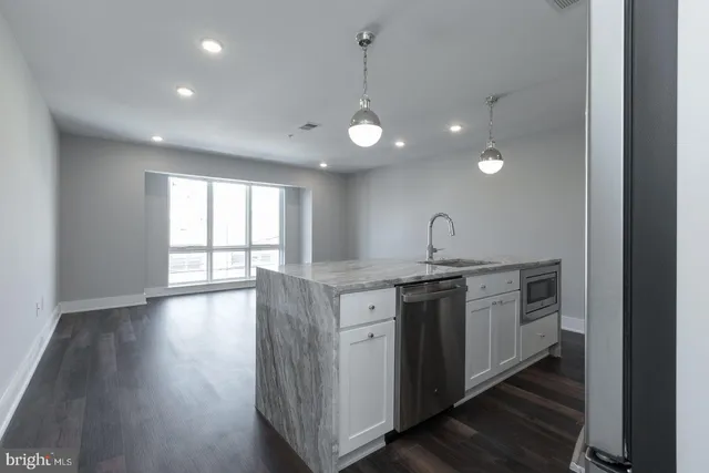 a kitchen with stainless steel appliances granite countertop a stove and a large window