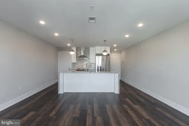 a view of kitchen and hall with wooden floor