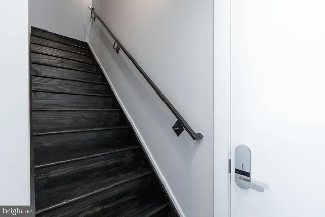 a view of staircase with white walls and railing