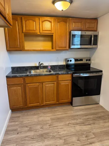 a kitchen with stainless steel appliances granite countertop a stove a microwave and a sink