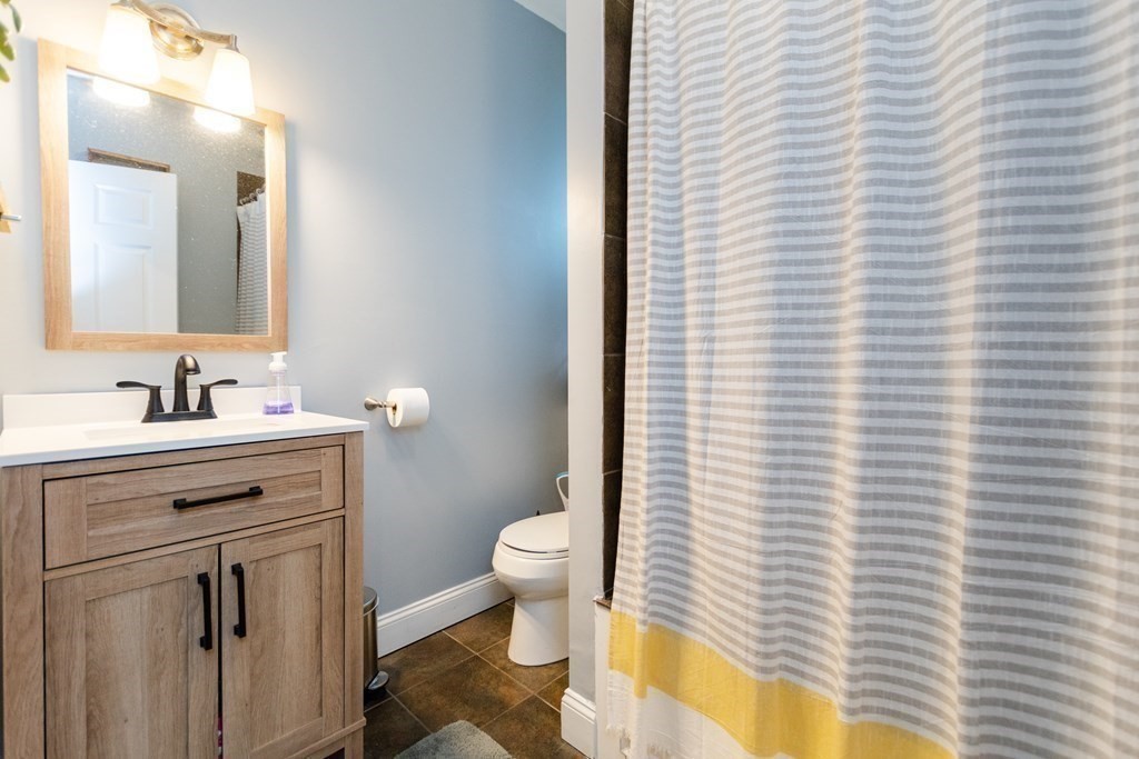 10 Beacon Street, Unit 3 Chelsea, MA 02150 - Photo 13 of 29 a bathroom with a sink a toilet a mirror and shower curtain