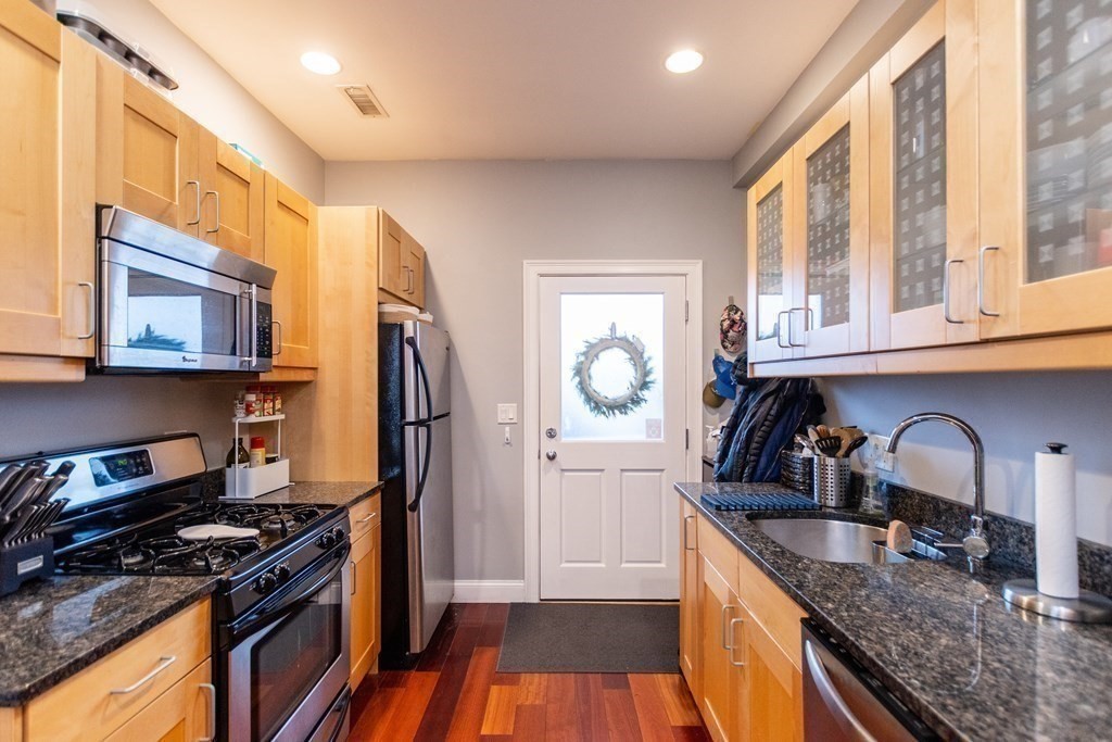10 Beacon Street, Unit 3 Chelsea, MA 02150 - Photo 16 of 29 a kitchen with granite countertop a stove a sink and a refrigerator