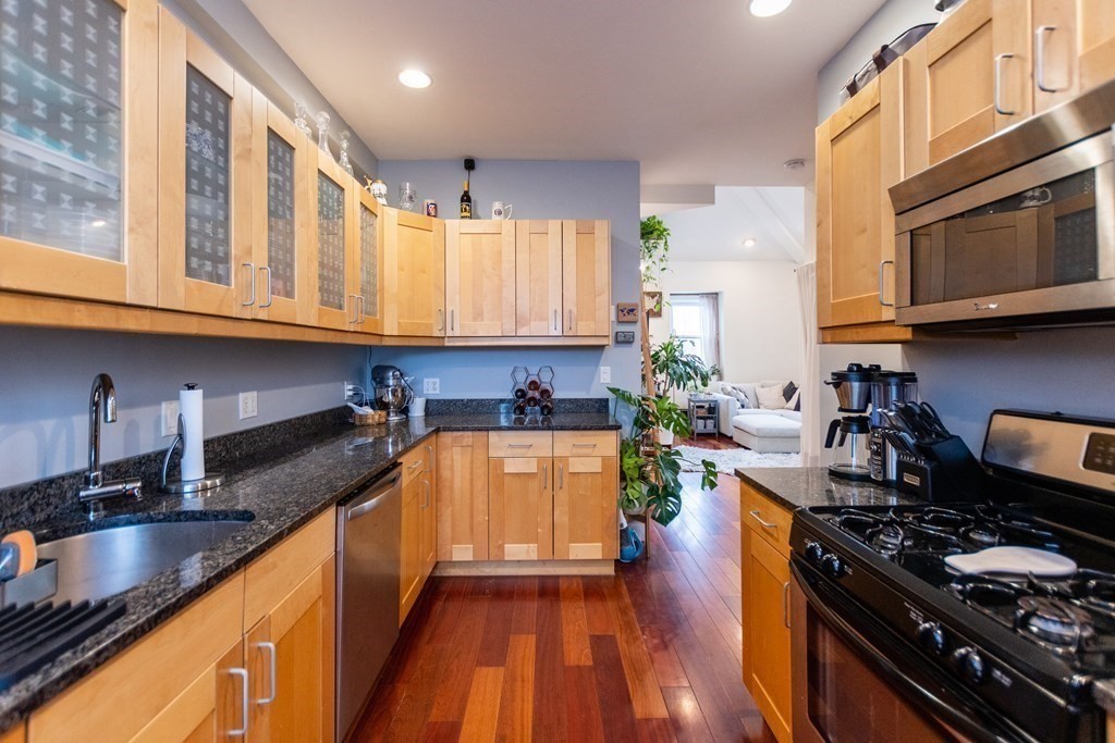 10 Beacon Street, Unit 3 Chelsea, MA 02150 - Photo 3 of 29 a kitchen with stainless steel appliances granite countertop a stove a sink and a microwave
