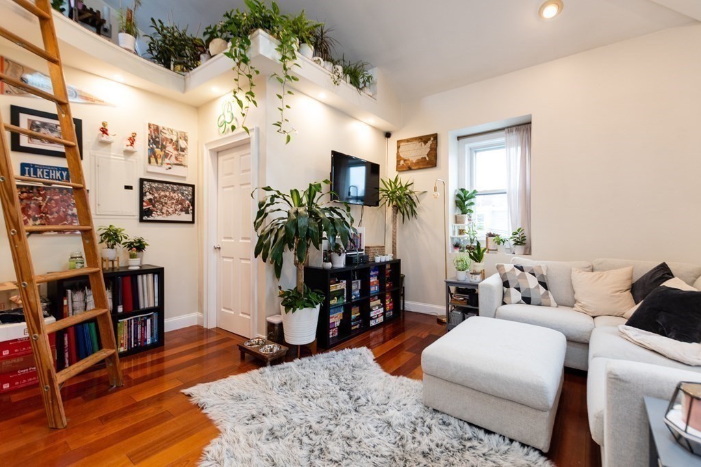 10 Beacon Street, Unit 3 Chelsea, MA 02150 - Photo 7 of 29 a living room with furniture and a book shelf
