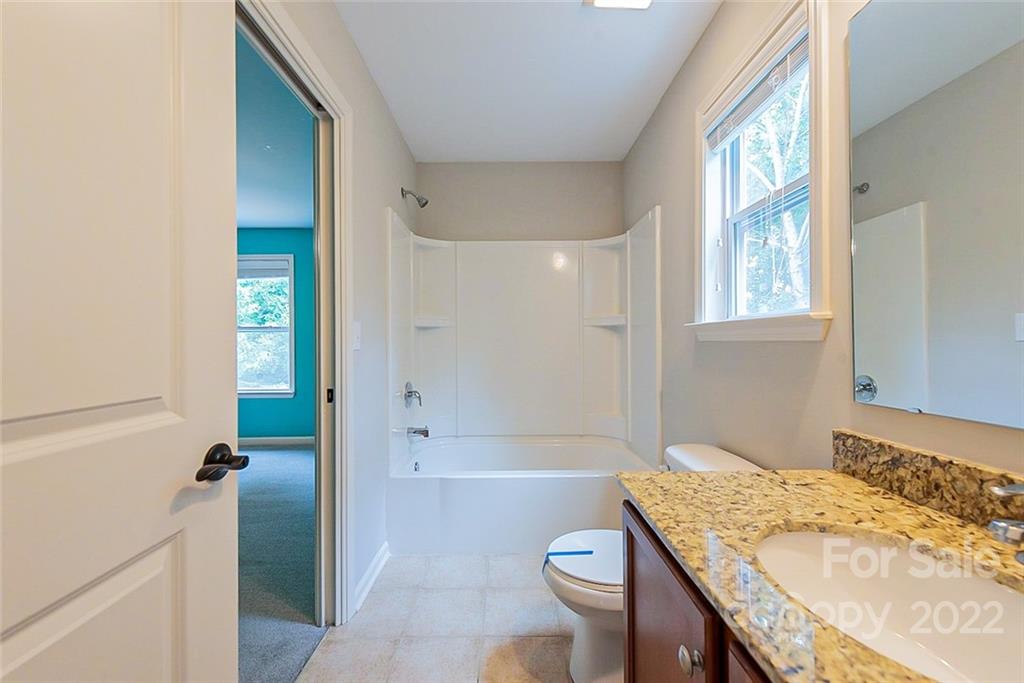 2138 Bluebell Way Tega Cay, SC 29708 - Photo 16 of 20 a bathroom with a granite countertop sink a toilet and shower