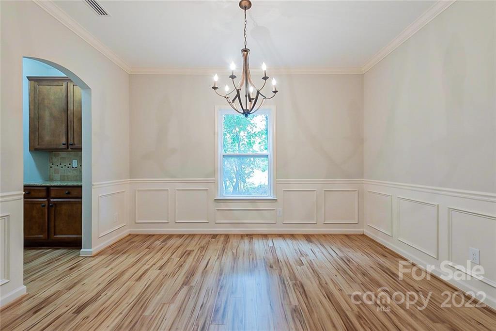 2138 Bluebell Way Tega Cay, SC 29708 - Photo 7 of 20 a view of an empty room with wooden floor and a window