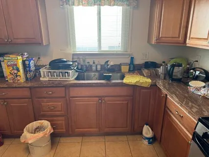 a kitchen with granite countertop a sink cabinets and window