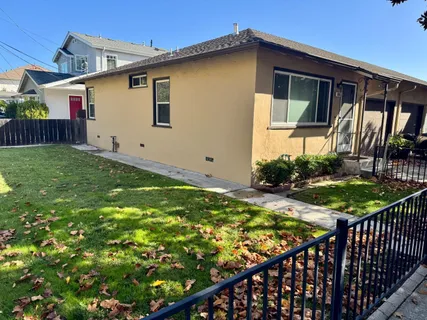 a view of a house with backyard and sitting area