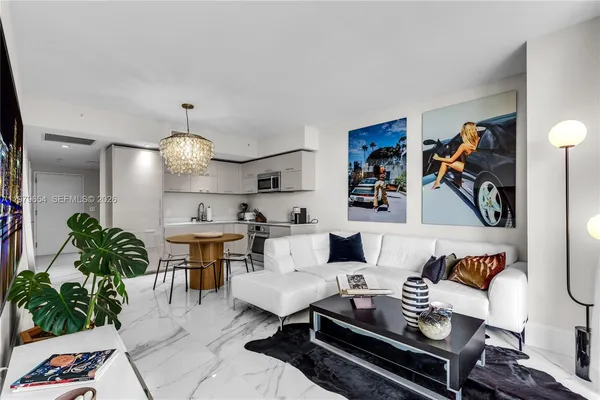 a living room with furniture piano and a chandelier