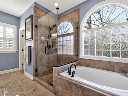 a bathroom with a tub a sink and a large mirror