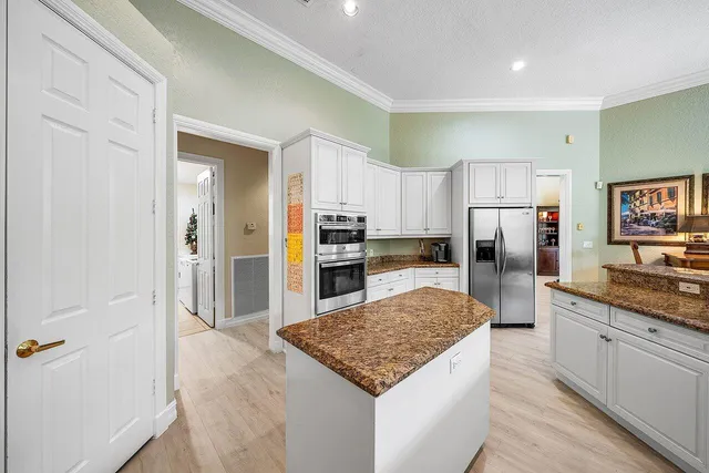 a large kitchen with a center island and stainless steel appliances